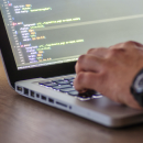 Someone writing code on a laptop